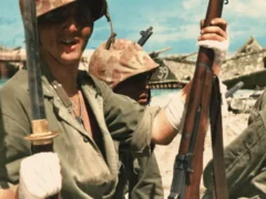 Photo colorisée prise après les combats sur Tarawa montre un marine blessé poser en montrant fièrement sa prise de guerre, un sabre Gunto d'officier japonais récupéré sur Betio